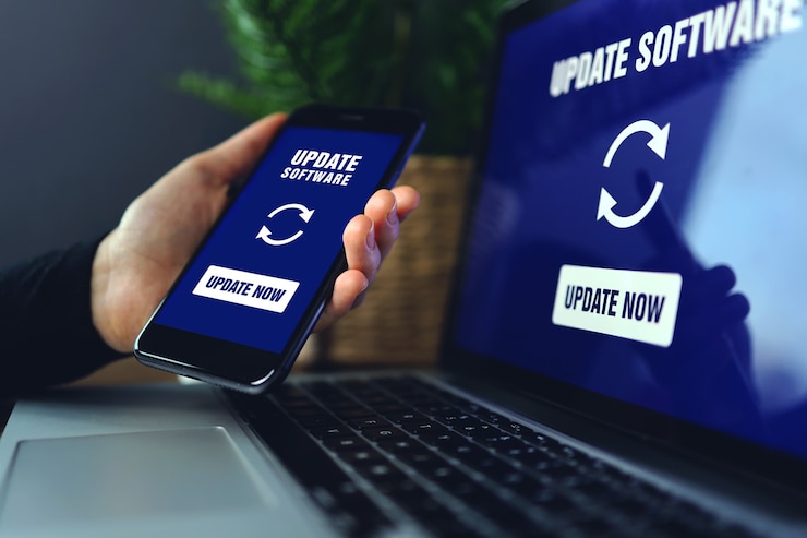 Zdjęcie dłoń trzymająca smartfona podczas instalacji procesu aktualizacji z procentowym postępem skrzyni biegów i paskiem ładowania z instalowaniem aktualizacji na tle laptopa na ekranie