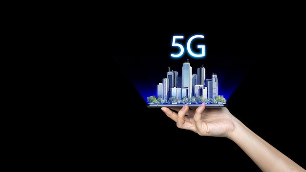 Dłoń trzymająca telefon z inteligentnym miastem 5G w tle Koncepcja sieci 5G szybkiego mobilnego Internetu sieci nowej generacji