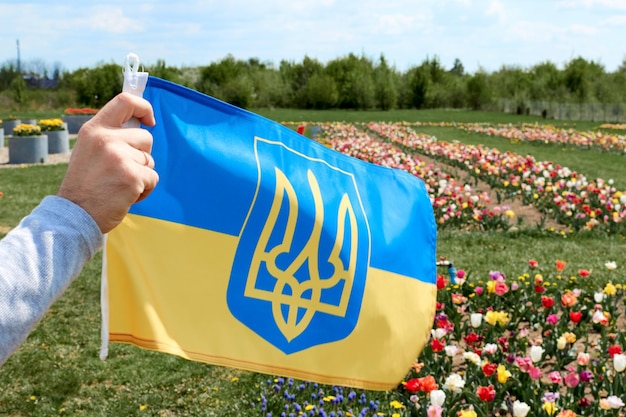 Zdjęcie dłoń trzymająca ukraińską flagę na żółtoniebieskim tle wojna rosji przeciwko ukrainie
