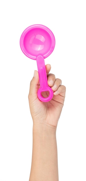 Dłoń trzymająca zabawka z tworzywa sztucznego różowy łopata na białym tle.