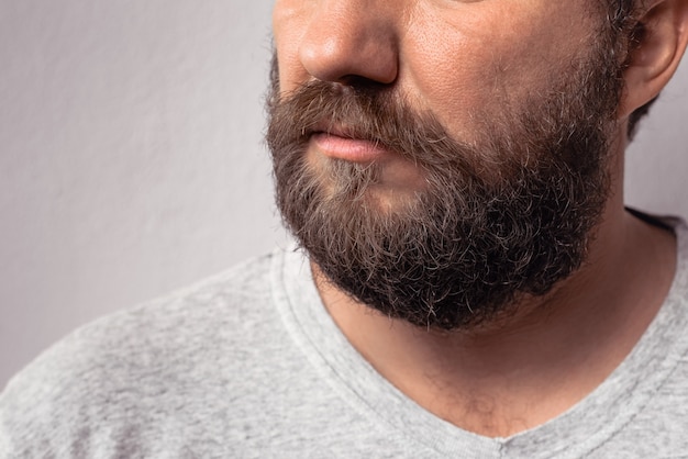 Długa broda i wąsy przystojnego brodatego mężczyzny portret brodatego mężczyzny w szarej koszulce