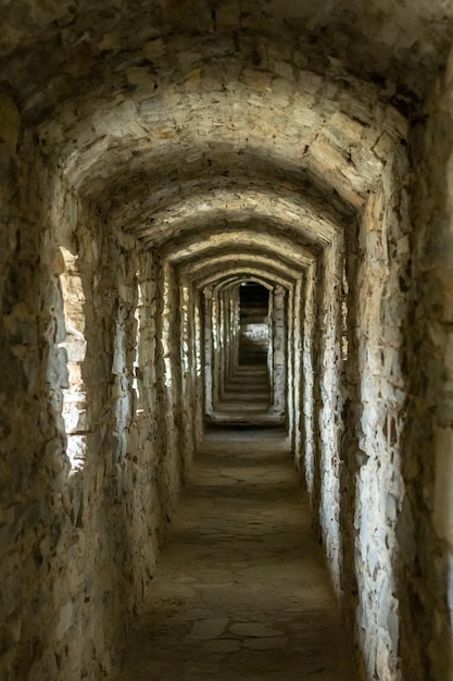 Długi kamienny korytarz tunelowy z oknami w starym zamku Selektywna ostrość