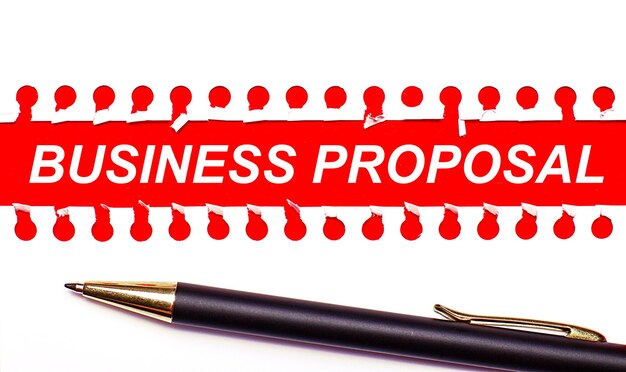 Długopis I Biały Podarty Papierowy Pasek Na Jasnoczerwonym Tle Z Tekstem Business Proposal