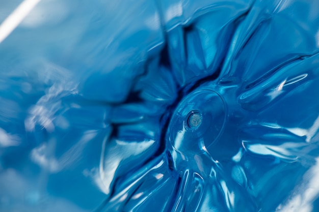 Zdjęcie dno niebieskiej butelki na wodę wykonane z grubego plastiku i zanieczyszczającej planety