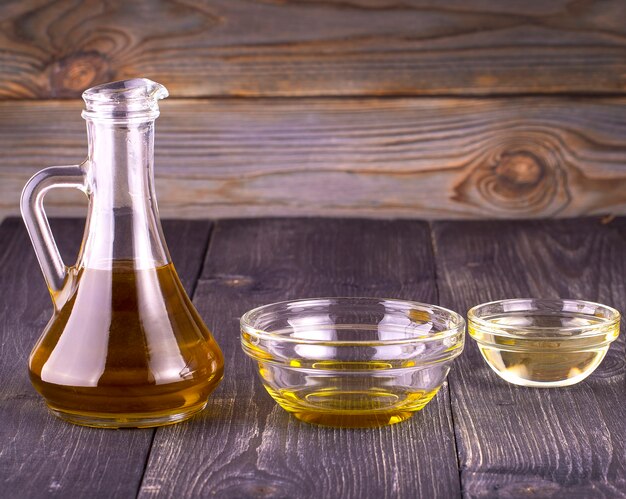 Do gotowania oleju roślinnego w małej szklanej filiżance i dzbanku na starym drewnianym stole