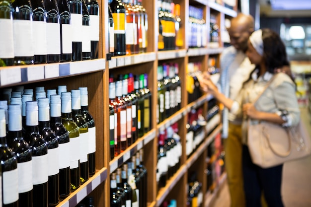 Zdjęcie dobiera się patrzeć wino butelkę w sklep spożywczy sekci