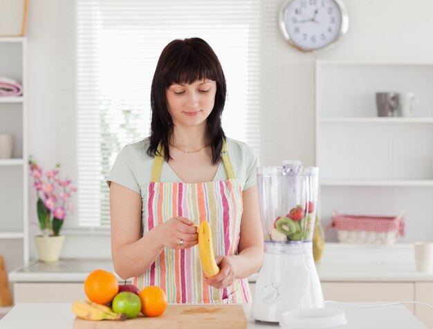 Dobra Przyglądająca Brunetki Kobieta Peeling Banana Podczas Gdy Stojący