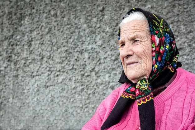 Zdjęcie dobra rozmyślna babcia z bliska siedząca w pobliżu domu