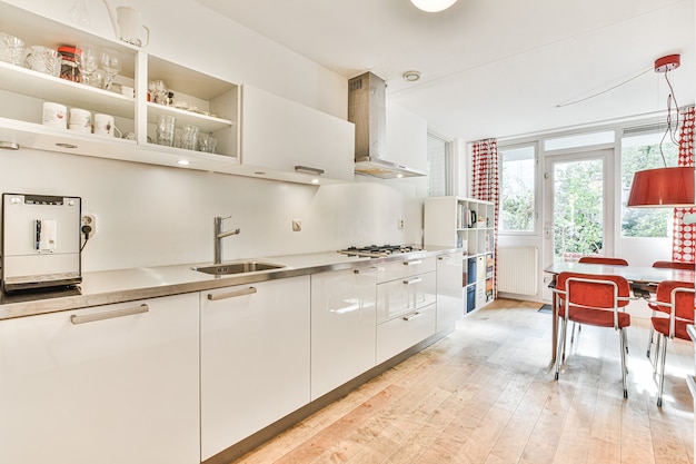 Dobrze zorganizowane małe domowe wnętrze kuchni ze zlewem i lekkimi meblami z piecem w mieszkaniu miejskim