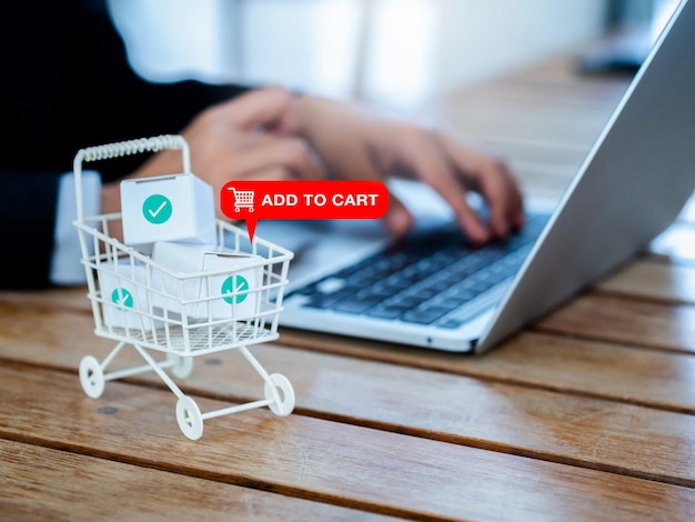 Dodaj do koszyka znak ikony pojawia się na białym wózku na zakupy koszyk zawierał paczki ze znacznikami wyboru w pobliżu osoby biznesowej, która korzysta z laptopa na zakupy online klient koncepcja klienta