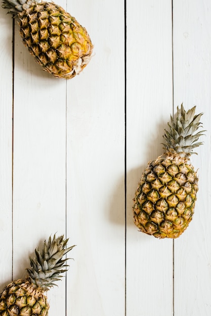 Zdjęcie dojrzała ananas granicy rama na białym drewnianym tle. koncepcja kreatywna owoców tropikalnych. pokój dla kopii, tekstu, liternictwa.