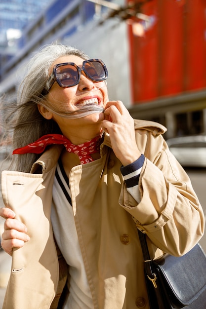 Zdjęcie dojrzała blada włosy stylowa kobieta styl życia portret na zewnątrz w mieście