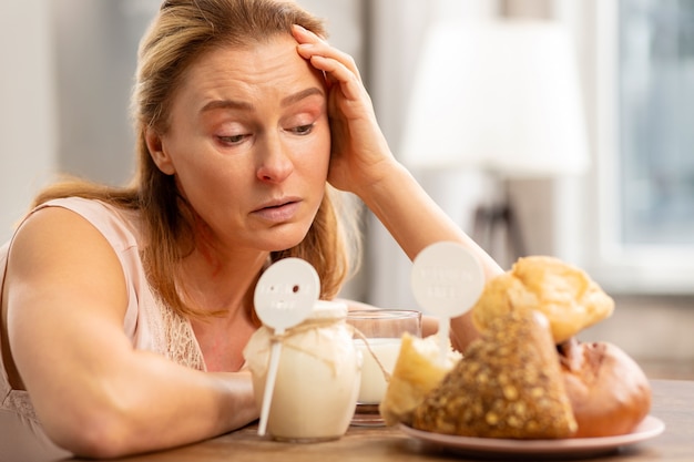 Dojrzała kobieta o blond włosach, która ma silną alergię na gluten i nabiał