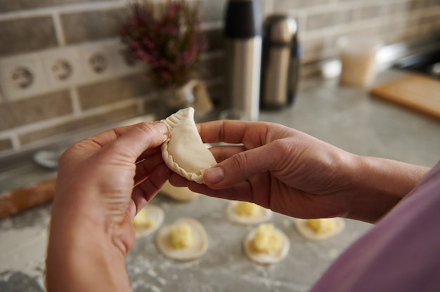 Dojrzała Kobieta Robiąca Tradycyjne Pierogi (vareniki Lub Ravioli)