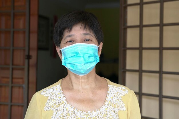Dojrzała Lub Starsza Chinka Z Twarzą Pokrytą Medyczną Maską Poza Jej Domem