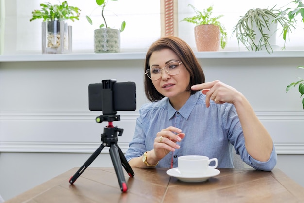 Dojrzała pewna siebie blogerka nagrywająca strumień wideo vlog