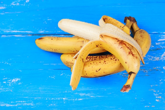 Dojrzałe banany na starym niebieskim drewnianym stole malowane