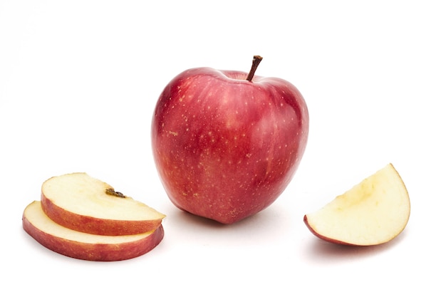 Zdjęcie dojrzałe czerwone jabłko z pokrojonymi kawałkami jabłka na białym tle