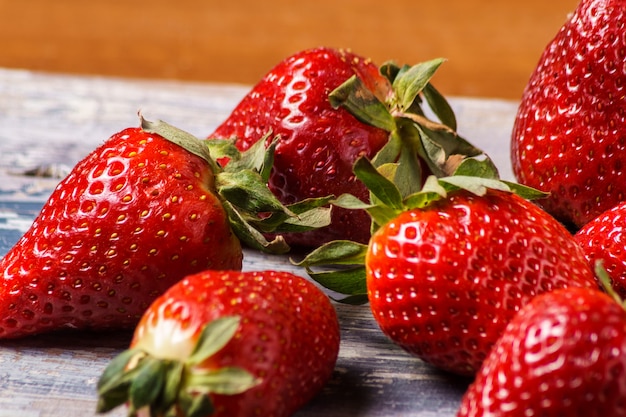 Dojrzałe organicznie truskawki na drewnianym tle, zakończenie up.