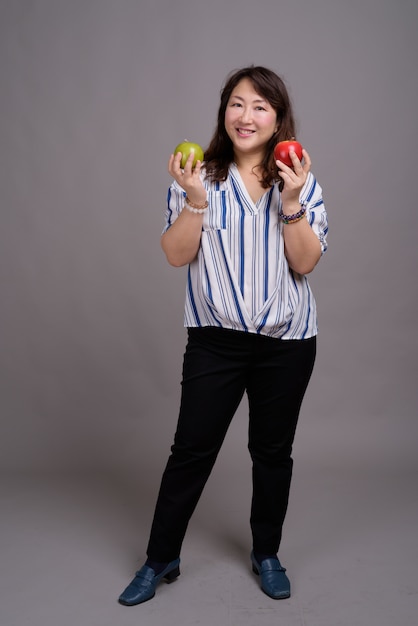 dojrzałe piękne azjatyckie bizneswoman gospodarstwa jabłka