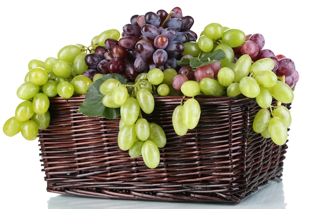 Dojrzałe zielone i fioletowe winogrona w koszu na białym tle