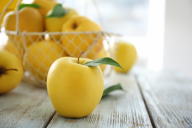 Dojrzałe żółte jabłko na drewnianym stole