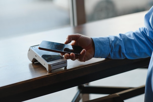 Dojrzały biznesmen płaci zbliżeniową kartą kredytową z technologią NFC
