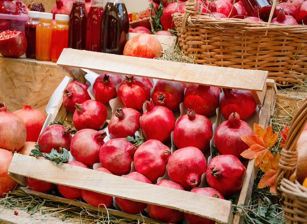 Dojrzały czerwony granat na ladzie na rynku lub w supermarkecie pełny kosz mandarynek dieta witaminowa z owoców organicznych
