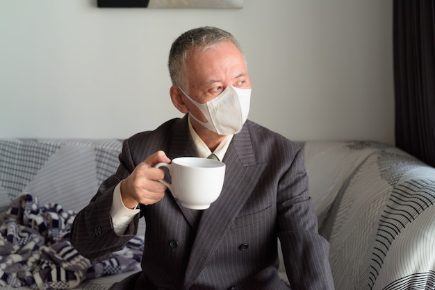 Dojrzały Japoński biznesmen zostaje w domu pod kwarantanną z maską