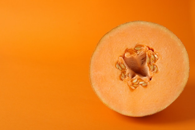 Dojrzały melon na pomarańczowym tle, miejsce na tekst