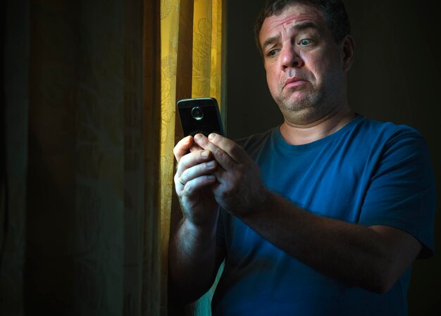 Zdjęcie dojrzały mężczyzna używający telefonu w pokoju w domu