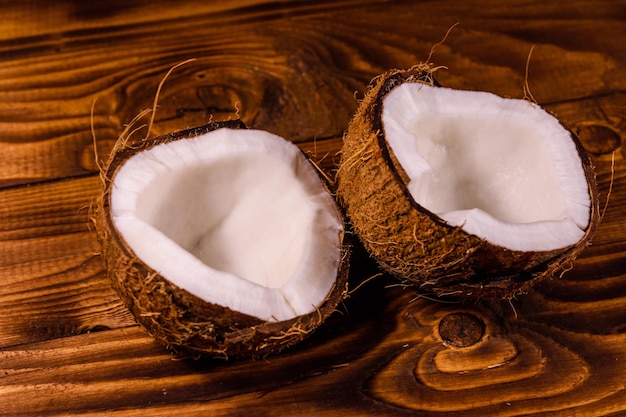 Dojrzały orzech kokosowy na pół na drewnianym stole