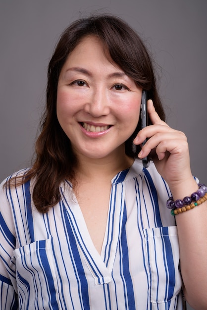 dojrzały piękny azjatycki bizneswoman przy użyciu telefonu komórkowego