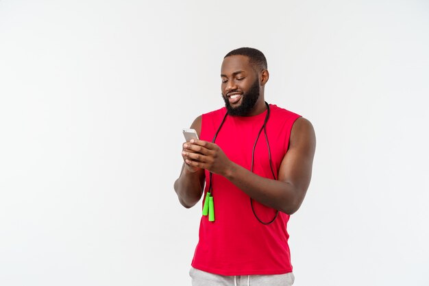 Dojrzały Sprawny Człowiek Afroamerykanów Sms-y Na Telefon Komórkowy I Trzymając Elastyczną Linę.