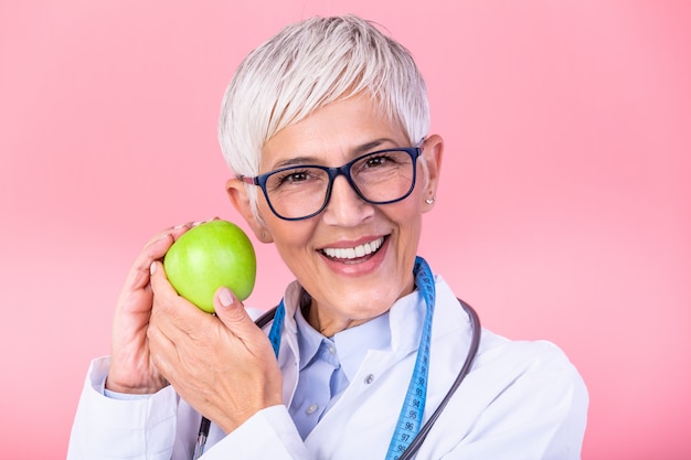 Dojrzały żeński dietetyk trzyma jabłka
