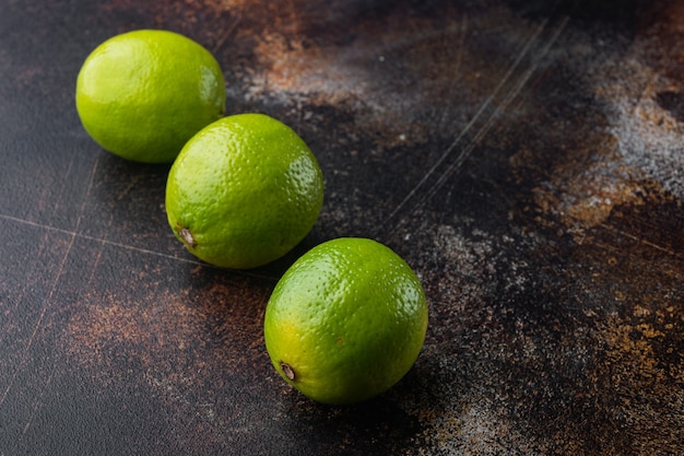 Dojrzały zielony zestaw limonki, na starym ciemnym stole rustykalnym