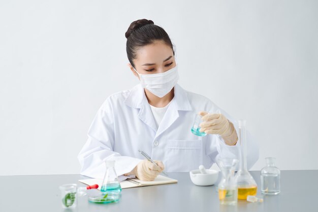 Doktor kobieta naukowiec podejmowania ziołolecznictwa w laboratorium z liści ziół suplementy witaminowe mineralne alternatywne badania leczenia.