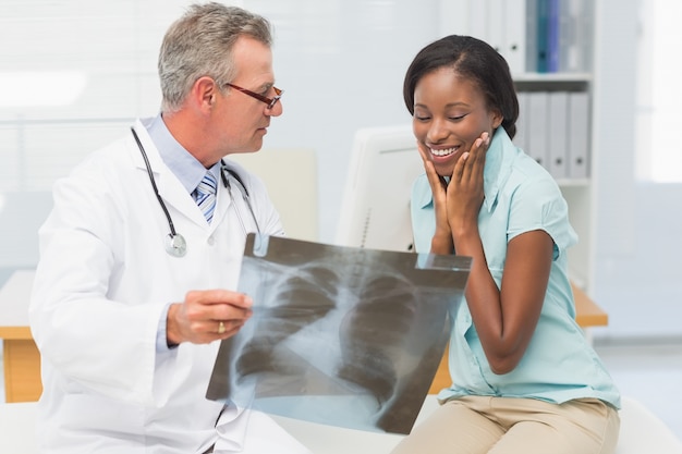 Doktorski pokazuje młody pacjent jej pozytywny klatki piersiowej xray