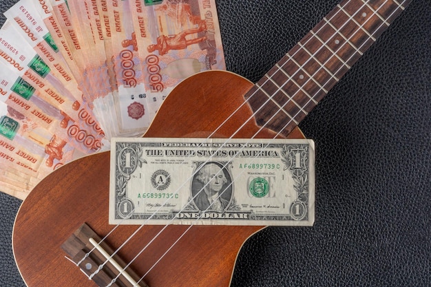 Dolar jest na gitarze z ukulele w tle.