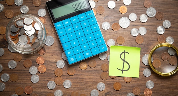 Zdjęcie dolarowy symbol na kleistej notatce z kalkulatorem i monetami business finance