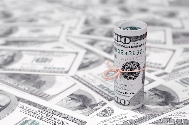 Dolary amerykańskie zwinięte i zaciśnięte z zespołem leżą na wielu amerykańskich banknotach