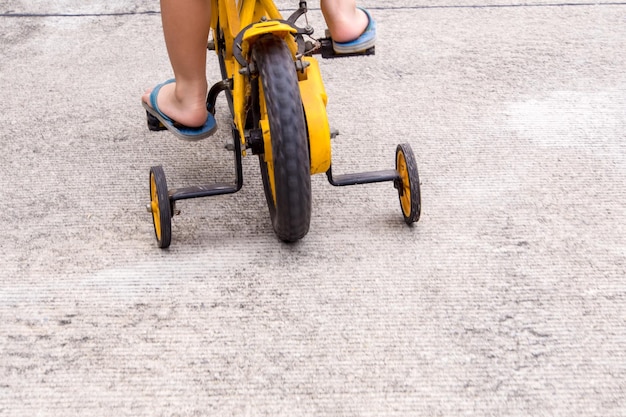 Zdjęcie dolna część dziecka jeżdżącego na rowerze po drodze