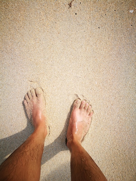 Dolna część mężczyzny stojącej na plaży