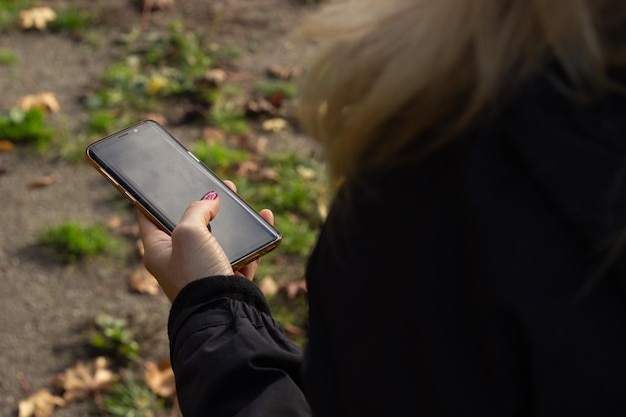 Zdjęcie dolna część osoby fotografującej telefonem komórkowym