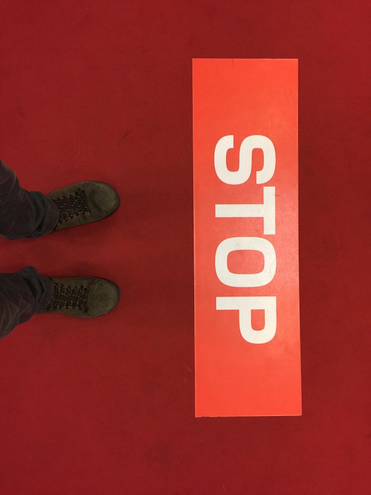 Zdjęcie dolna część osoby stojącej przy znaku stopu