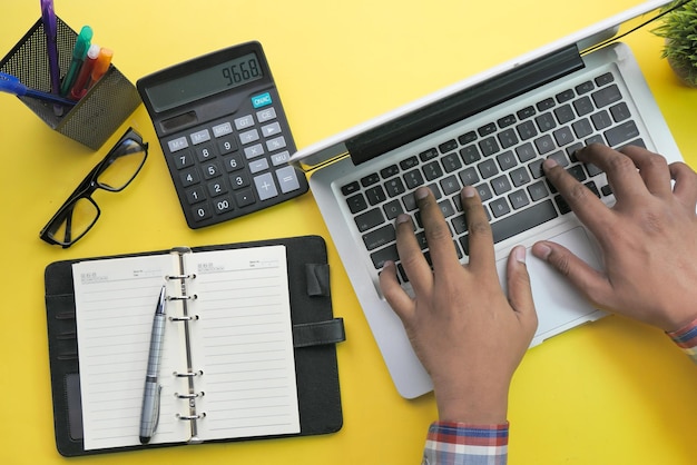 Zdjęcie dolna część osoby używającej laptopa na stole