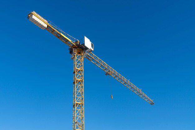 Zdjęcie dolny widok wyboju i kabiny dźwigu budowlanego na tle niebieskiego nieba