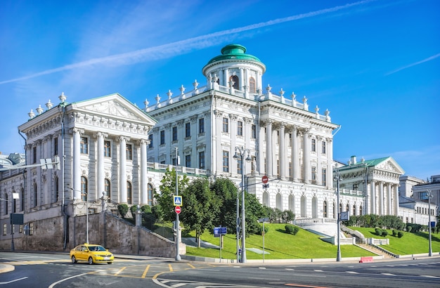 Dom Paszkowa w Moskwie i żółta taksówka w słoneczny letni dzień