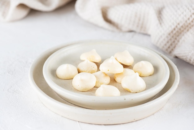 Domowa beza aquafaba na talerzu na stole. Wegański deser bez cukru, bez laktozy.