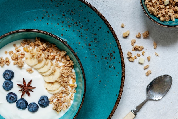 Domowa granola śniadaniowa, musli ze świeżą dojrzałą jagodą, banan, biała czekolada i naturalny jogurt